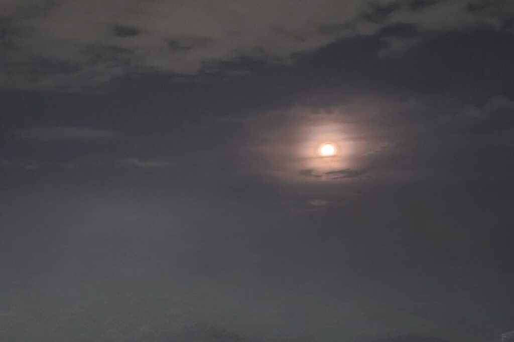 雲の合間に輝く朝の満月（2025年11月5日、大阪で撮影）