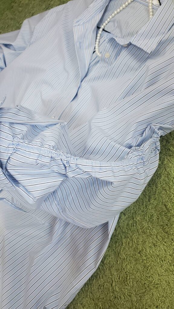 ブルーのストライプシャツにパールネックレスを合わせたコーディネート例